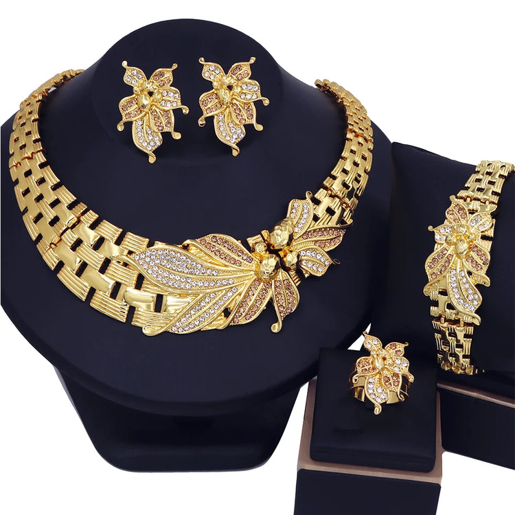 Alt Tag: 18K gold plated wedding jewelry set for women featuring crystal floral necklace, earrings, bracelet and ring on black display