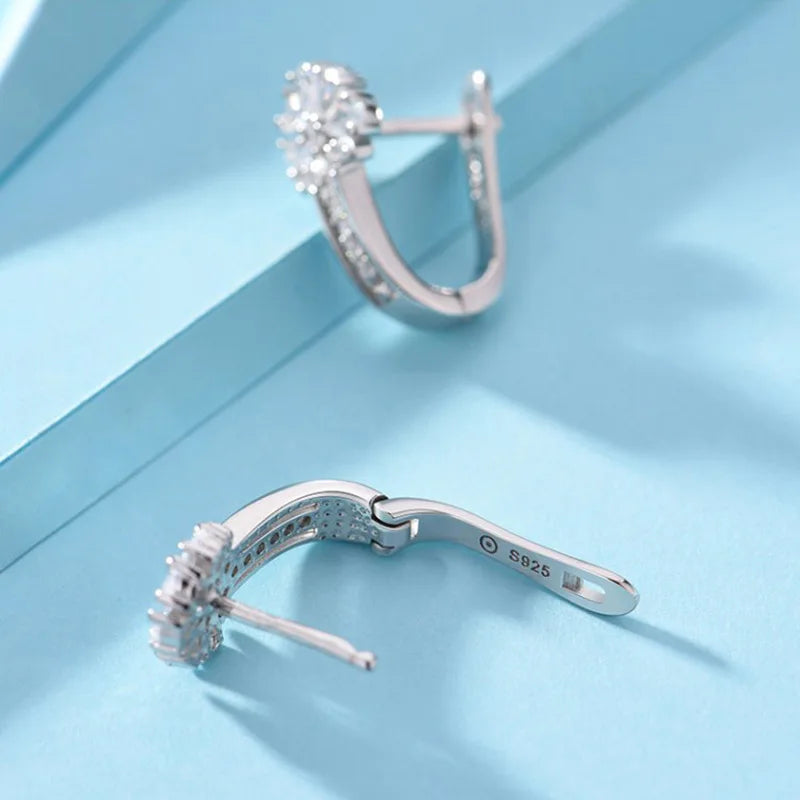 Alt Tag: 925 sterling silver zircon flower earrings S925 stamped leverback hoops with sparkling floral zircon cluster, close-up on blue background