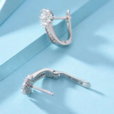 Alt Tag: 925 sterling silver zircon flower earrings hoop-style, sparkling floral cluster studs, S925 stamped, close-up on blue background