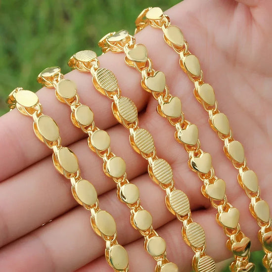 Gold Islamic necklace 70cm displayed in a hand, featuring geometric shapes and heart patterns in shiny finish.