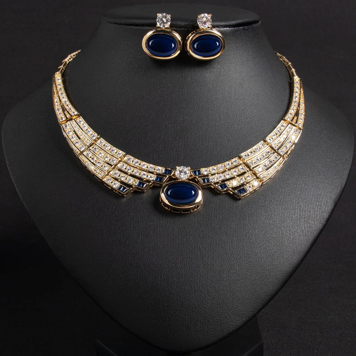 Alt Tag: bridal necklace and earrings set with gold-tone crystal collar necklace and blue oval stones, matching stud earrings on display bust