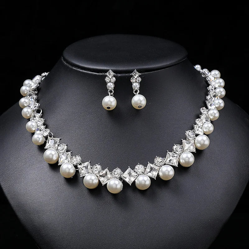 Alt Tag: pearl necklace and earrings set for women featuring white pearls and crystal rhinestones on black display bust