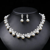 Alt Tag: pearl necklace and earrings set for women featuring white pearls and crystal rhinestones on black display bust