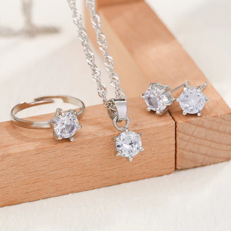 Alt Tag: 5 piece crystal jewelry set for women with silver-tone ring, pendant necklace and crystal stud earrings on wooden display