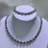 Alt Tag: pearl jewelry set wholesale for weddings silver-toned rhinestone necklace and bracelet set on white display for bridal wear