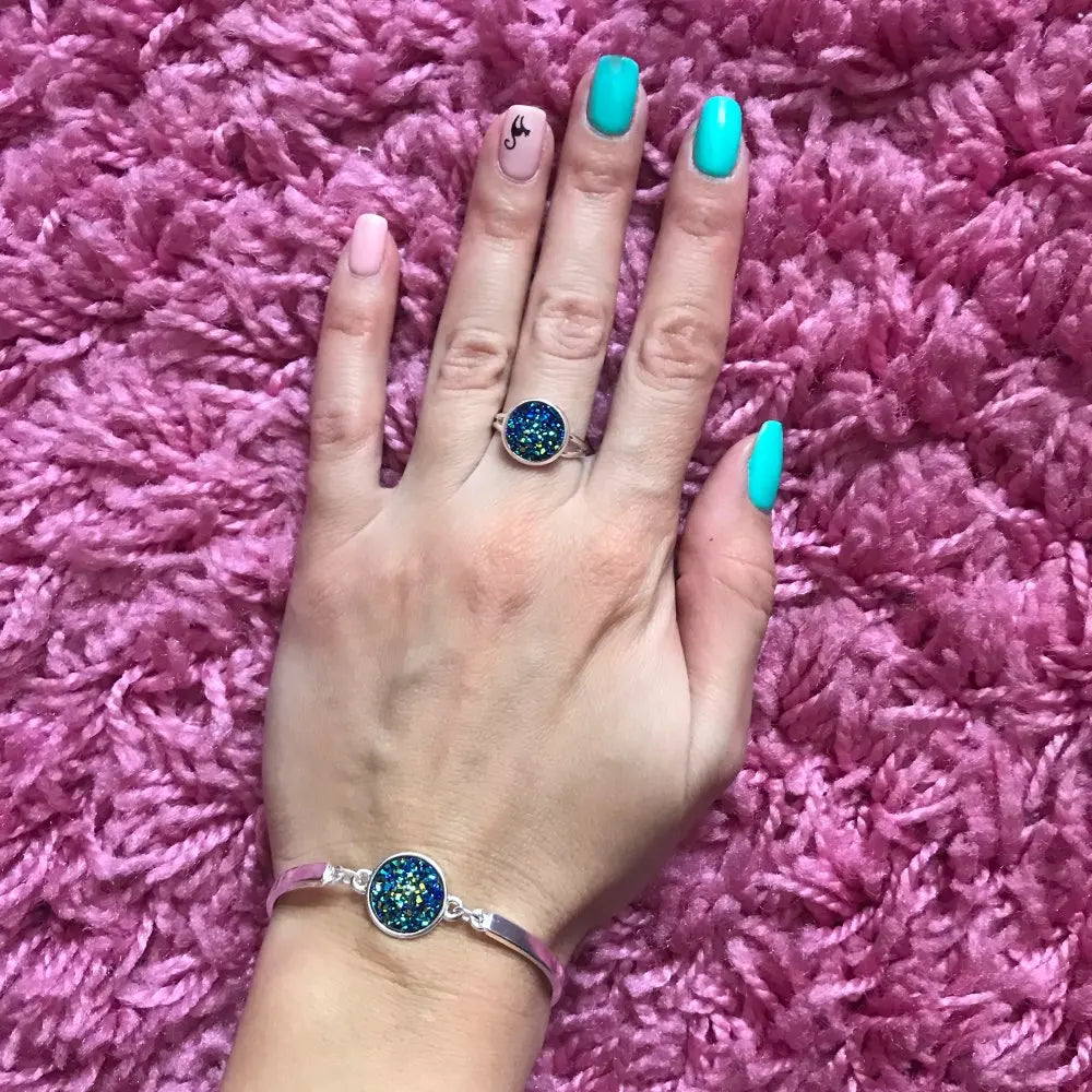 Alt Tag: silver plated rhinestone jewelry set for women shown as blue druzy ring and matching bracelet on hand