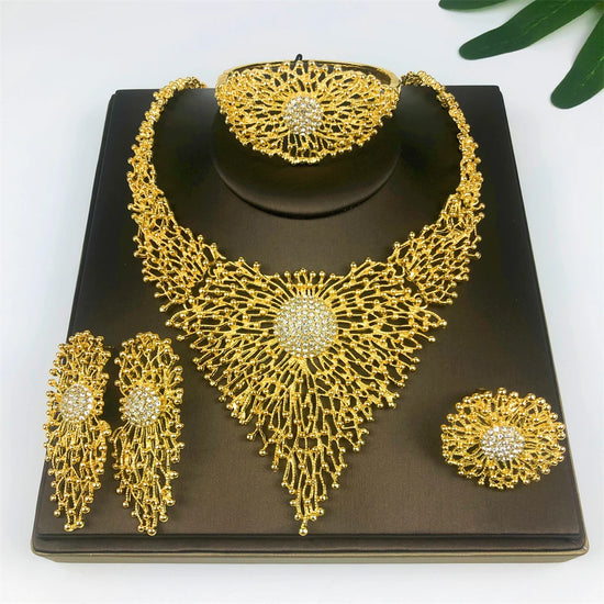 Alt Tag: 18K gold plated jewelry set for women with ornate necklace, bracelet, earrings and ring on black display