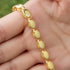 Close-up of a gold Islamic necklace 70cm held in hand, featuring smooth, oval links for a stylish look.
