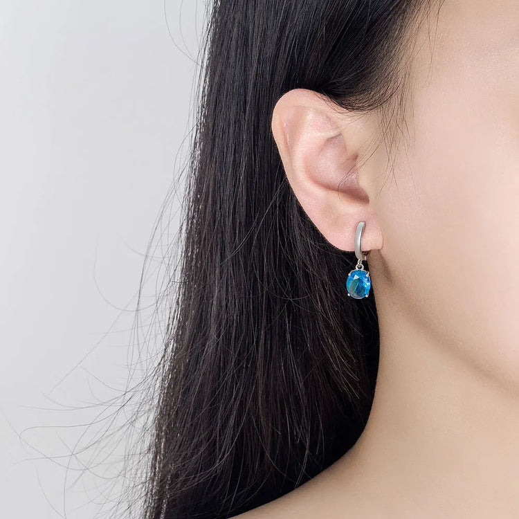 Alt Tag: 925 sterling silver bridal jewelry set blue gemstone drop earring on model ear, elegant wedding jewelry