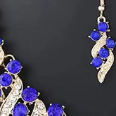 Alt Tag: crystal bridal necklace and earrings set with blue crystals and silver leaf design, elegant wedding jewelry close-up